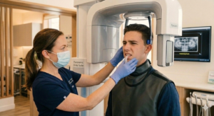 Dentist examining a patient with jaw pain because of TMJ disorder